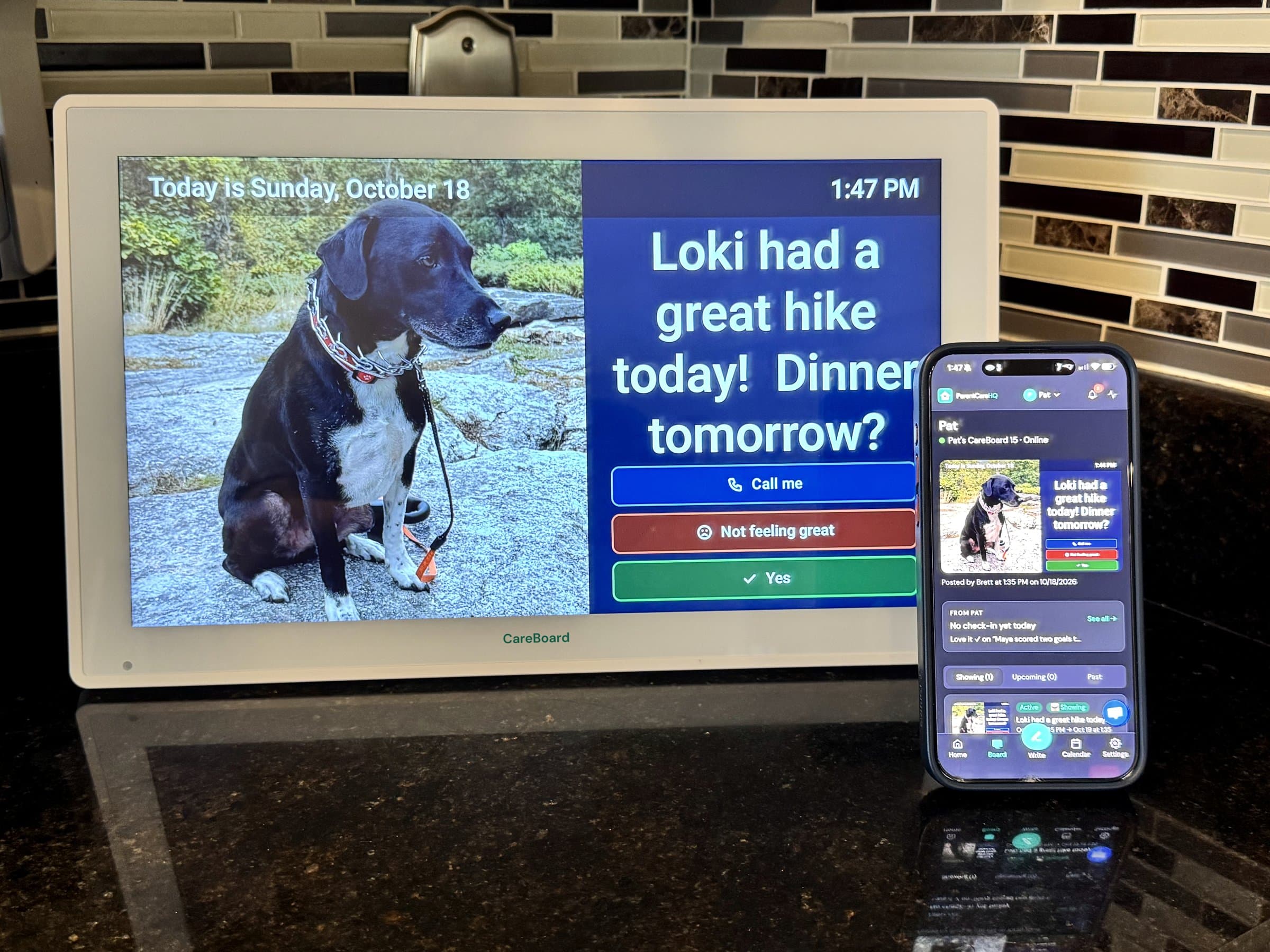 CareBoard on a kitchen counter showing a photo of a dog with the message Loki had a great hike today, Dinner tomorrow?, next to a phone showing the same message in the ParentCareHQ app